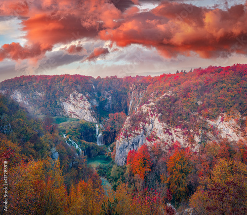 Red hills in canyon of Plitvice National Park, Croatia, Europe. Dramatic morning view of pure water waterfall in Plitvice. Splendid autumn sunrise in mountain forest. 