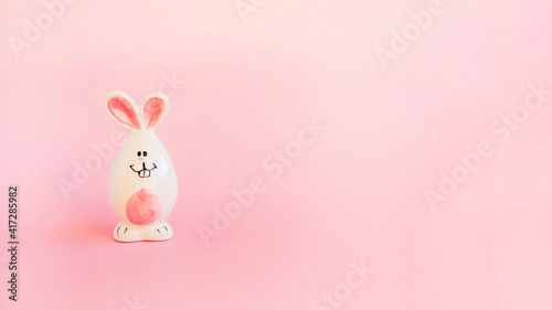 Cute white ceramic easter bunny or rabbit on pink background. Minimal Holiday concept. Symbol Happy Easter holiday. Creative. Copy space