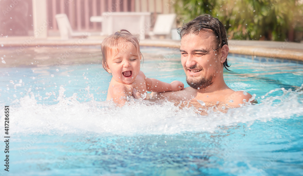 Father with a child in the pool.