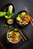 Asia style ramen soup with udon noodle, beef, shiitake, pak choi cabbage and carrots