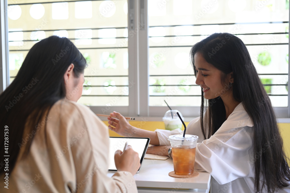 Two young woman small business entrepreneur planning and discussing on their new project. Two young woman small business entrepreneur planning and discussing on their new project.