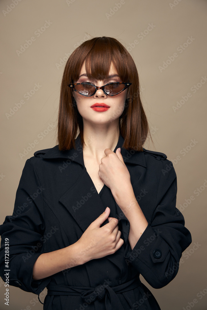 Stylish Woman in a coat touches the collar with his hand elegant appearance Stylish Woman in a coat touches the collar with his hand elegant appearance