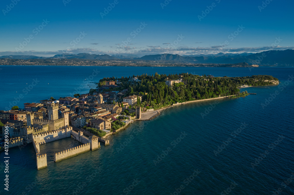 Panoramic aerial view early in the morning, Sirmione, an ancient village on southern Garda Lake, Italy.  Rocca Scaligera Castle in Sirmione. View by Drone