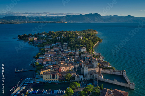 Fototapeta Naklejka Na Ścianę i Meble -  Aerial view on Sirmione sul Garda. Italy, Lombardy. View by Drone early in the morning. Rocca Scaligera Castle in Sirmione.