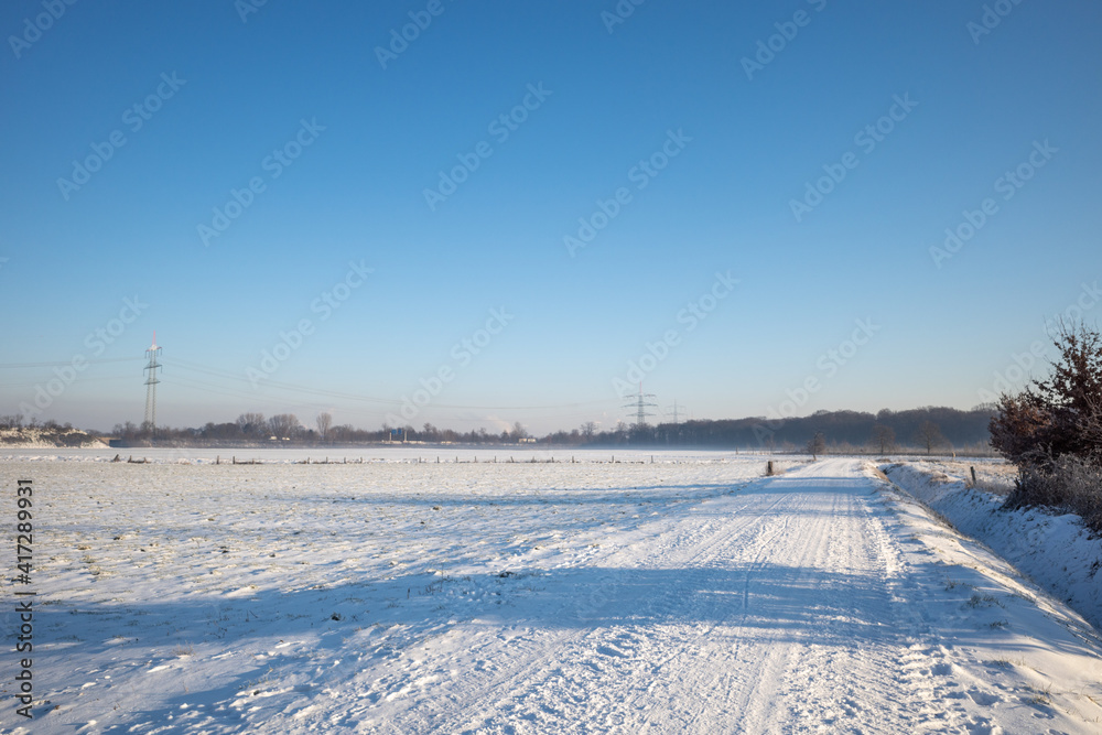 Outdoor sunny view of thick layer snow cover street, land and field in countryside in Germany during winter season. Outdoor sunny view of thick layer snow cover street, land and field in countryside in Germany during winter season.