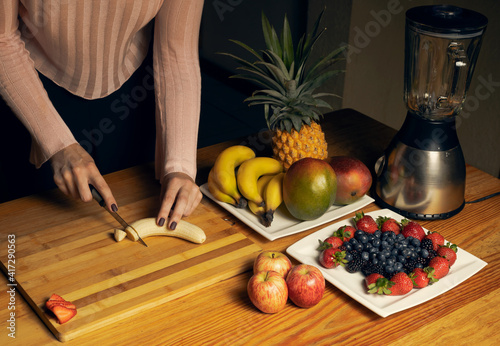 Girl cutting a banana for a smoothie