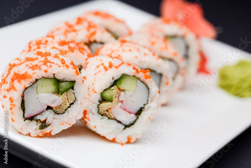 Maki Sushi - Roll made of smoked salmon and cream cheese. Traditional Japanese cuisine concept, over black background.