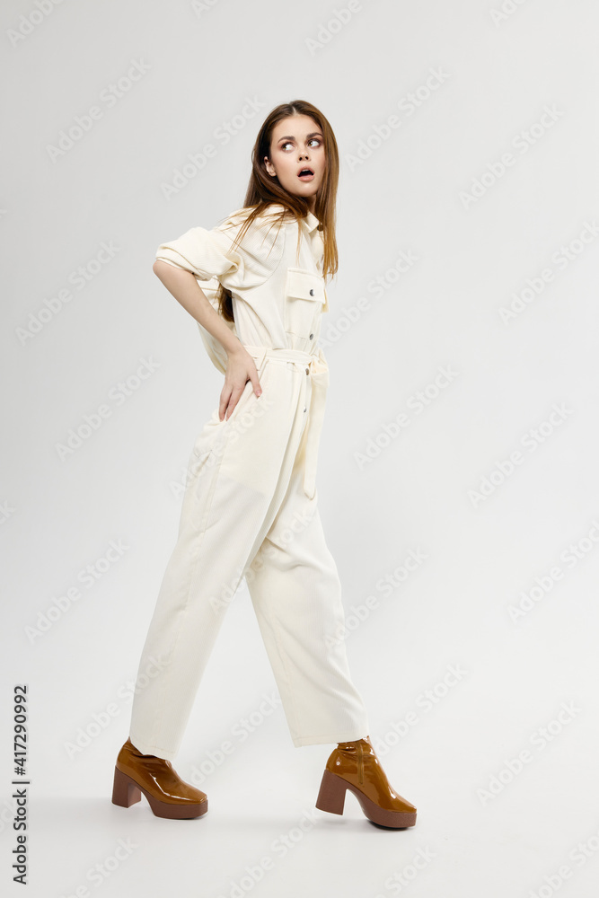 emotional woman in suit brown shoes look aside light background