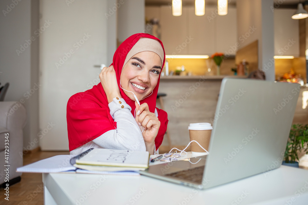 Muslim woman working. Pretty woman wearing hijab in front of laptop ...