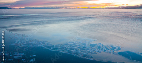 Young thin ice and blue waters of Lake Baikal freezing in autumn on a morning.
