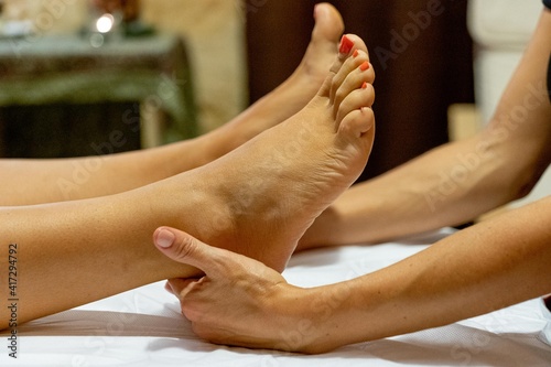Masseuse giving a foot massage to a client © Jennifer