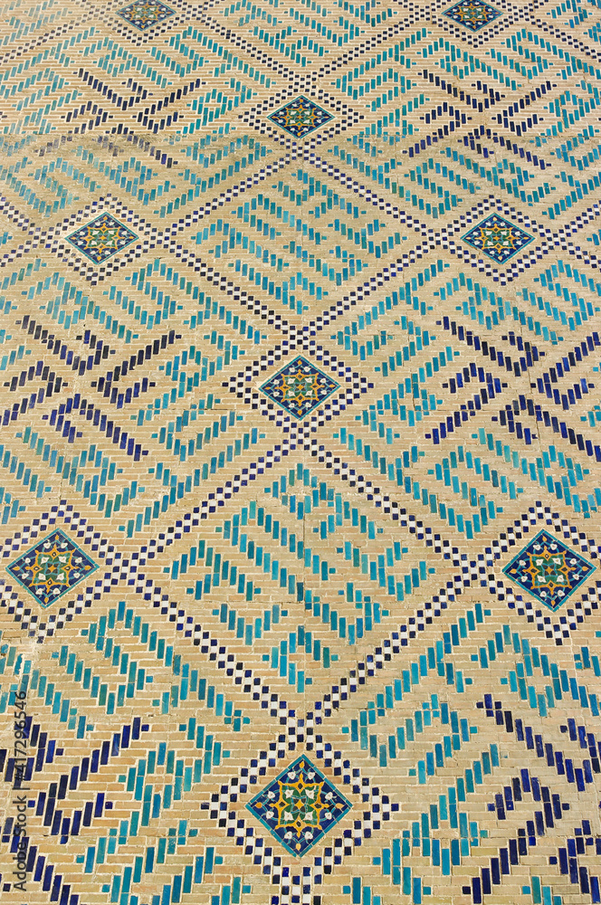 Traditional blue and turquoise tile geometric decoration on brick wall of ancient Bibi Khanum or Khanym mosque in UNESCO listed Samarkand, Uzbekistan Traditional blue and turquoise tile geometric decoration on brick wall of ancient Bibi Khanum or Khanym mosque in UNESCO listed Samarkand, Uzbekistan