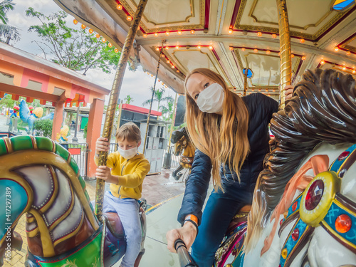 Family wearing a medical mask during COVID-19 coronavirus at an amusement park © galitskaya