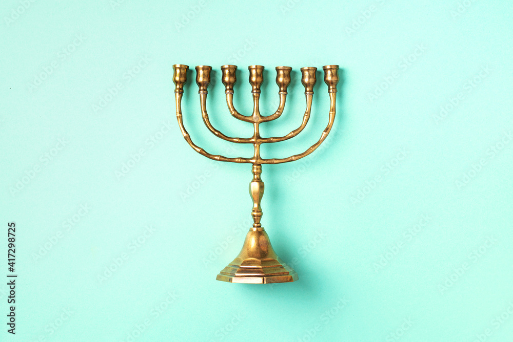 Golden hanukkah menorah on blue background. Jewish holiday banner with copy space. Ancient ritual religious candle menorah