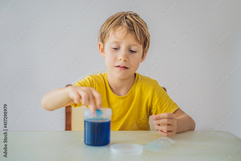 Chemical home tests. Tools for the home lab. the boy Explorer. Child is watching a chemical reaction. The young chemist doing scientific experiments. physical experiment inside