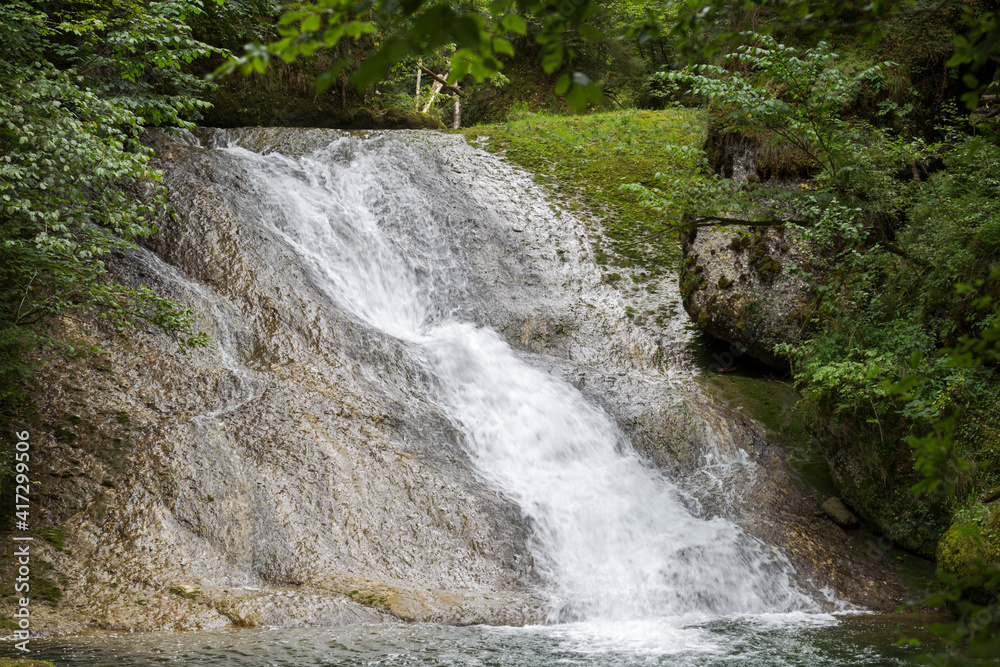 Foaming water at the waterfall of a mountain stream in Argentobel in Allgäu Foaming water at the waterfall of a mountain stream in Argentobel in Allgäu