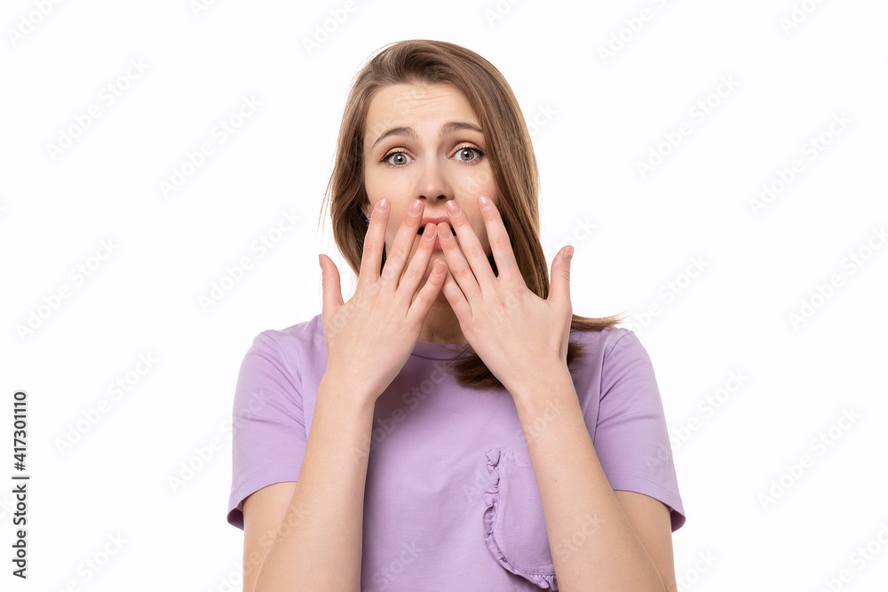close up shocked young woman covering her mouth with hands, isolated on white background close up shocked young woman covering her mouth with hands, isolated on white background