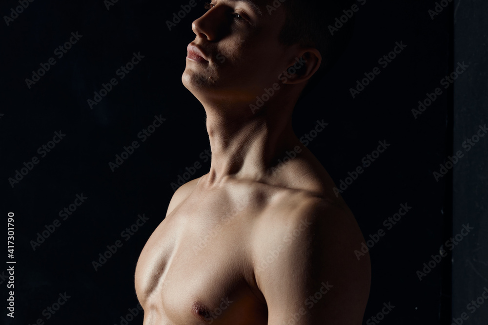 portrait of an athlete with a naked torso on a black background side view Copy Space