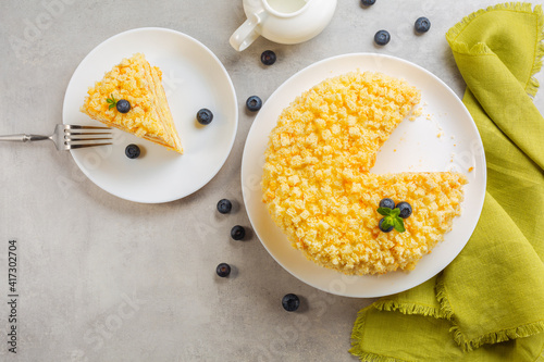 Top view of traditional italian Mimosa cake,  decorated with sponge cubes and crumbles, blueberries and mint. Horizontal image. photo