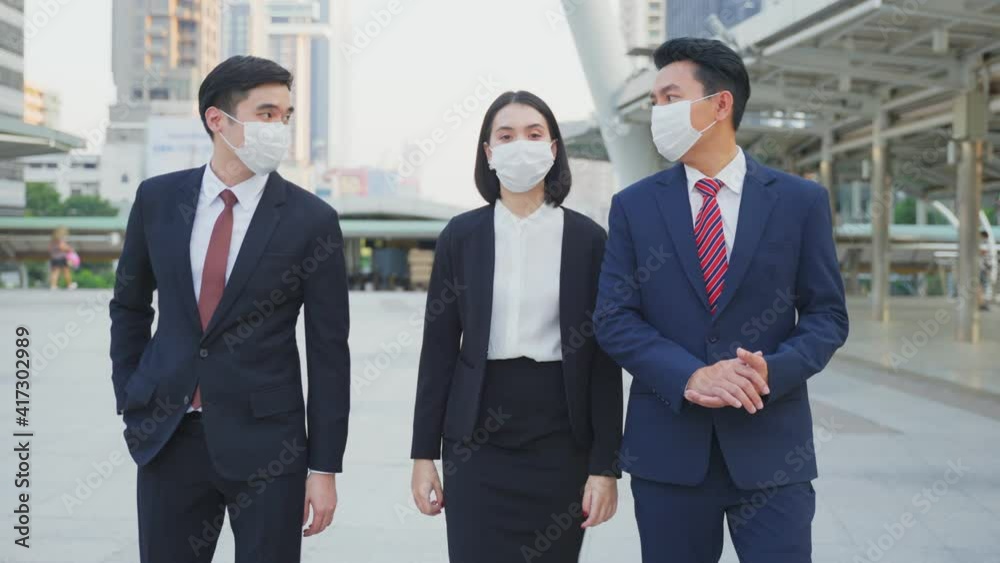 Group of business people wearing face mask walking outdoor in the city Group of business people wearing face mask walking outdoor in the city