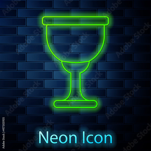 Glowing neon line Holy grail or chalice icon isolated on brick wall background. Christian chalice. Christianity icon. Vector.