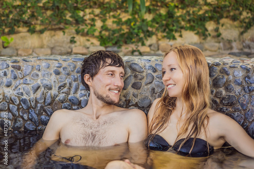 Couple at spa relaxing in round outdoor fragrant herbal bath, organic skin care, luxury spa hotel, lifestyle photo