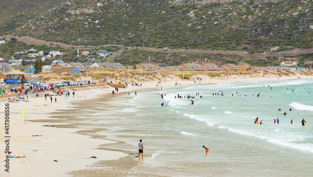 Swimmers frolicking in the shallow waves of Fish Hoek beach