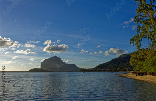 The Tourelle de Tamarin Mountain seem from the edge of the tree lined Le More Beach one evening in September as the Sun goes down.