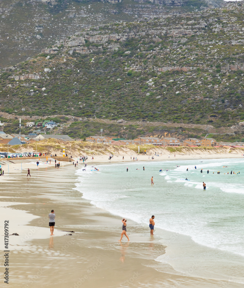 Swimmers frolicking in the shallow waves of Fish Hoek beach