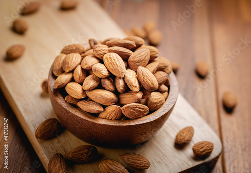 Almonds seed in the wooden bowl on the wooden table.