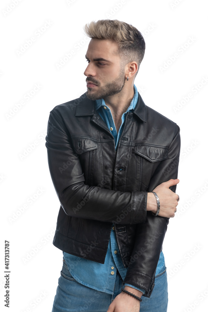 attractive bearded man in leather jacket looking to side and posing attractive bearded man in leather jacket looking to side and posing