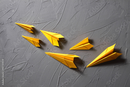Yellow paper airplanes flying out  on a gray background
