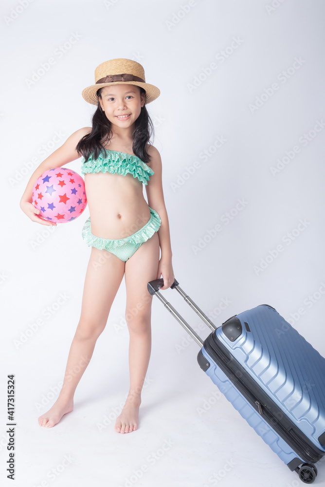 child bikini holding a beach ball. little stylish lady girl in swimsuit,  relaxing isolated white background. lovely photo for advertising,copy space  for text. beach vacation concept. Stock Photo