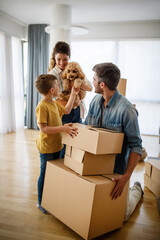 Happy family with children moving with boxes in a new apartment house.