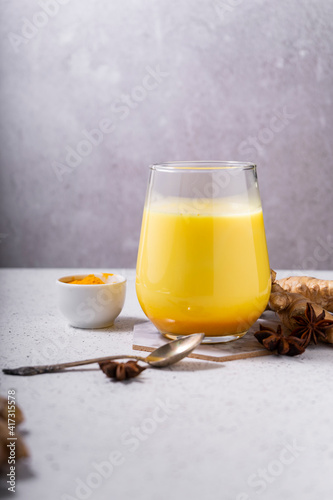 selective focus. Healthy ayurvedic drink golden almond milk or pumpkin turmeric latte with curcuma powder on white background. copy space.Trendy Asian natural detox beverage with spices for vegans