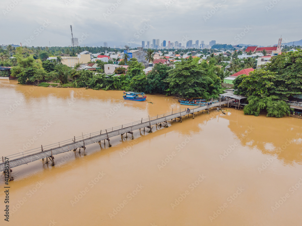 Fototapeta premium Aerial view of old wooden bridge over the river. Drone