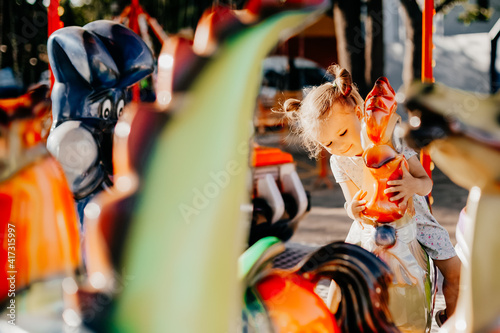 The girl rides an amusement park in the park located on the shores of a seaside resort. Happy child on vacation with family