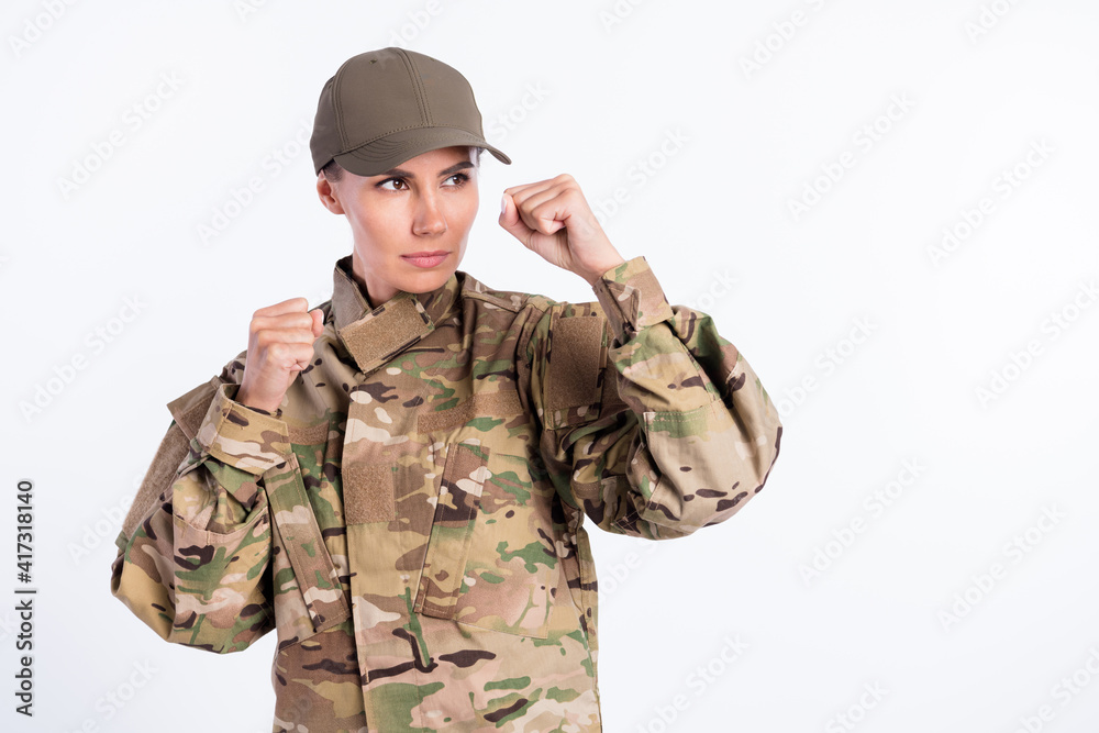 Portrait of composed young girl raise fists up look attentively empty space isolated on white color background Portrait of composed young girl raise fists up look attentively empty space isolated on white color background