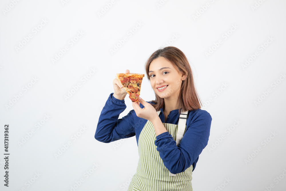 Portrait of woman in apron posing with slice of pizza on white background Portrait of woman in apron posing with slice of pizza on white background