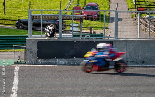 A shot of a racing motorbike as it circuits a track. © SnapstitchPhoto