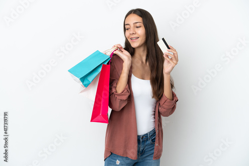 Young French girl isolated on white background holding shopping bags and a credit card