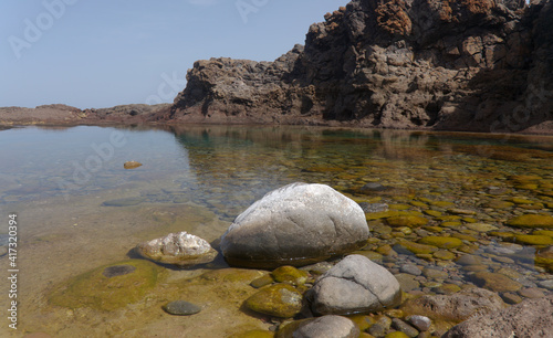Gran Canaria, calm natural seawater pools in under the steep cliffs of the north coast and separated from the ocean by volcanic rocks, Sardina del Norte area 