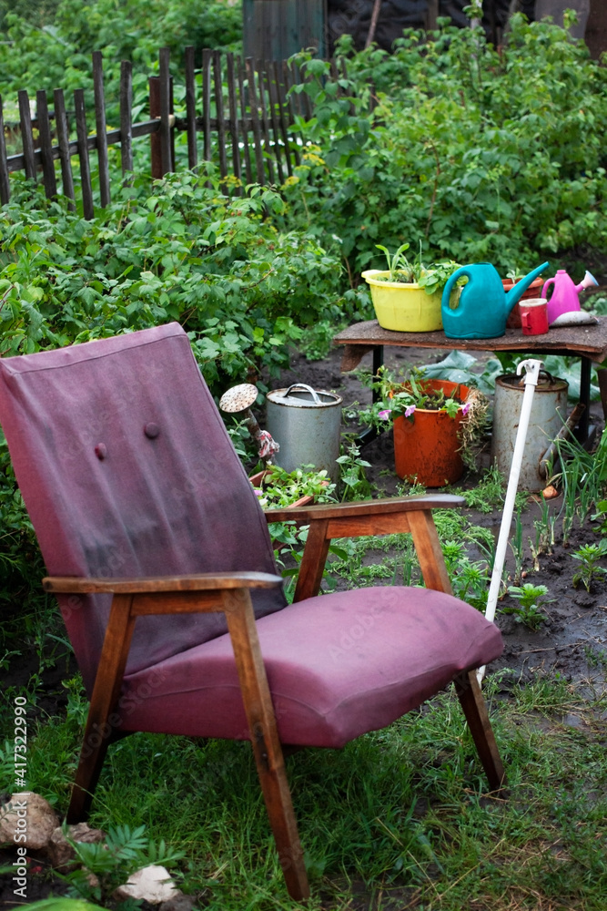 Old chair with flowerpot and blooming summer flowers. Cozy place in the garden to relax. Old chair with flowerpot and blooming summer flowers. Cozy place in the garden to relax.
