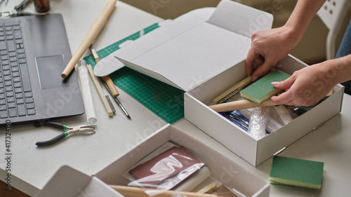 unrecognizable woman entrepreneur collects goods in a box and is about to send a parcel through a courier company. delivery service concept photo