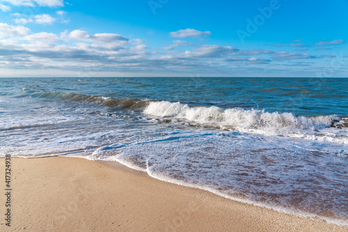 Empty beach with yellow sand and blue waves, quarantine at the resort