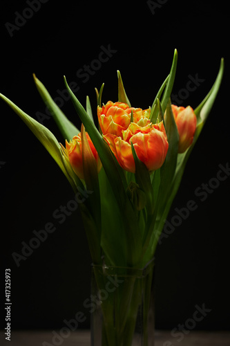 bouquet with beautiful orange terry tulips on a black background