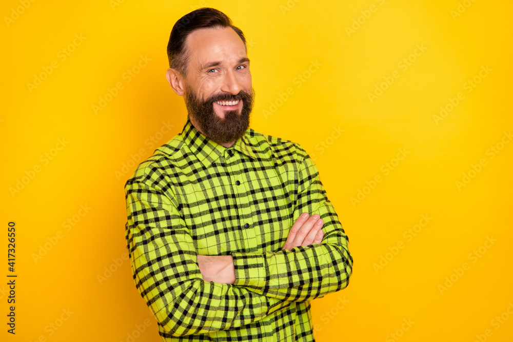 Profile side photo of mature cheerful man happy positive smile confident crossed hands isolated over yellow color background