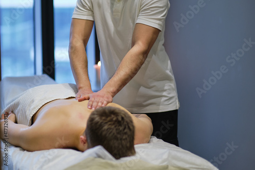 Close-up of man enjoying in relaxing shoulders massage . Man relaxing on massage table receiving massage © yavdat