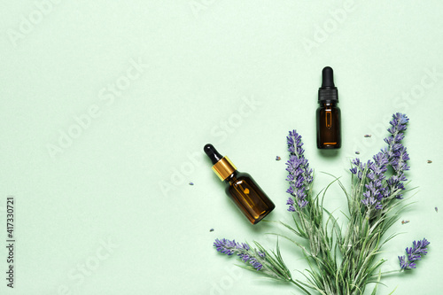 Lavender essential oil on mint green background. Aromatherapy treatment and Skincare spa cosmetics concept