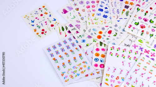 multicolored stickers for manicure on a white background, background